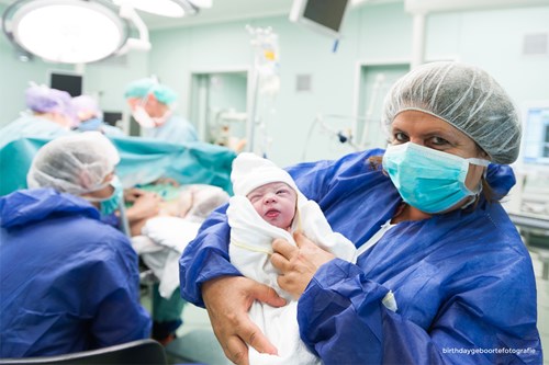 Verpleegkundige met baby op de arm na een natuurlijke keizersnede