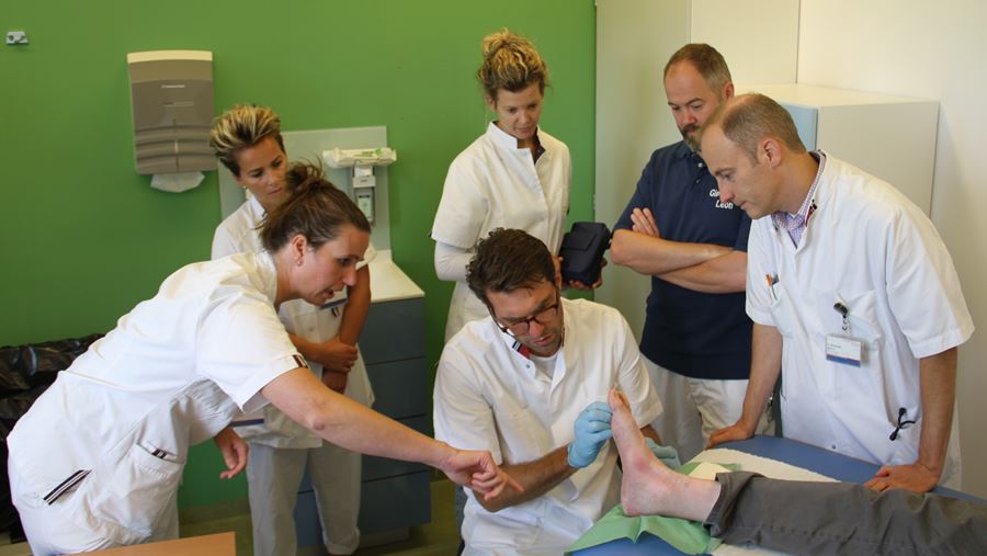 Het wondteam bekijkt gezamenlijk de voet van een diabetespatiënt Het wondteam bekijkt gezamenlijk de voet van een diabetespatiënt