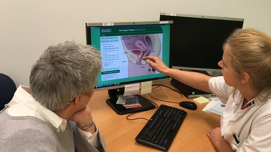Arts kijkt met patiënt op scherm