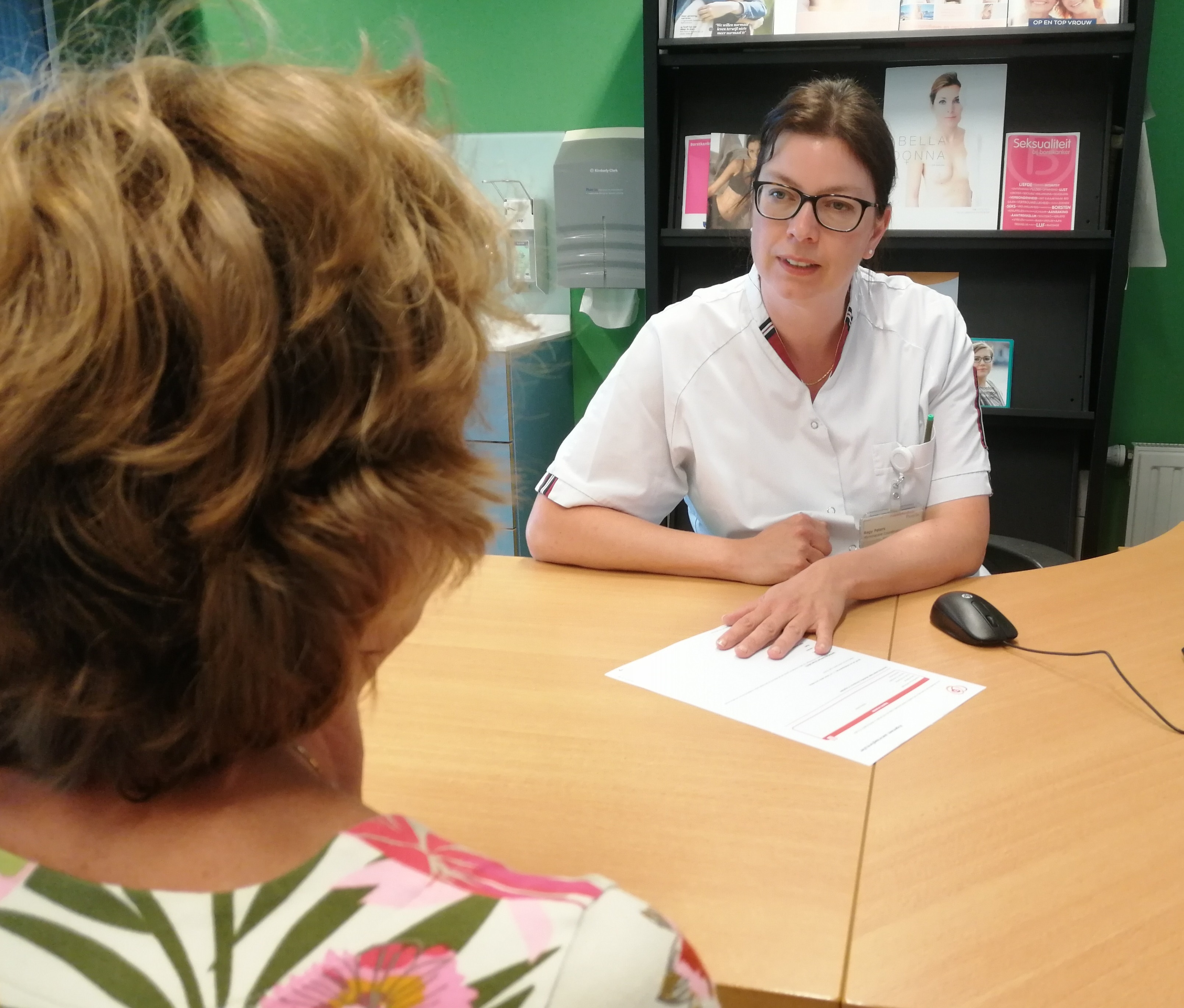 Verpleegkundige in gesprek met patiënt