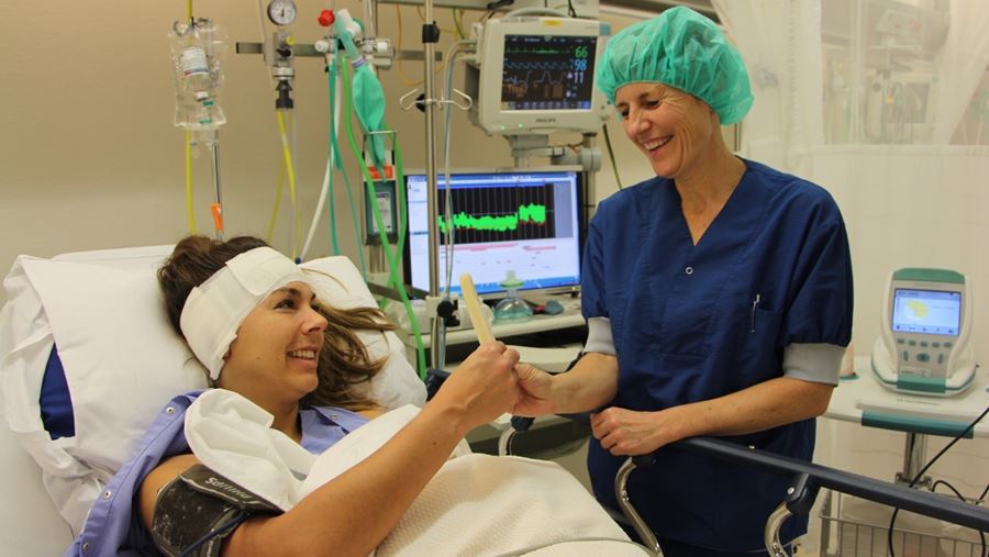 Verpleegkundige geeft patient een waterijsje Verpleegkundige geeft patient een waterijsje